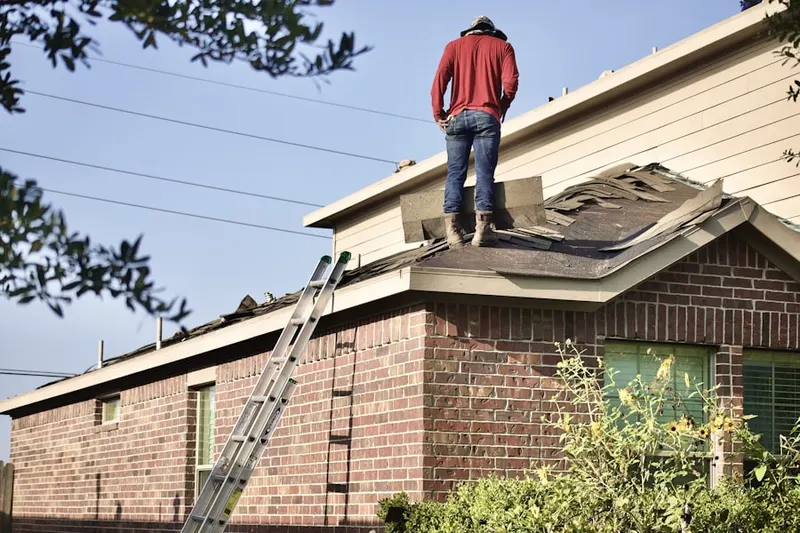 Professional roofer working on a residential roof in Triana
